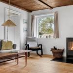 Living room with fireplace, sofa, table, and window view.