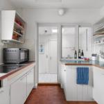 Kitchen with white cabinets, wooden surfaces, and kitchen appliances.
