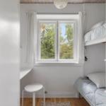 Room with bunk bed, window, and desk.