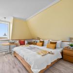 Bedroom with large bed, window view, and wooden furniture.