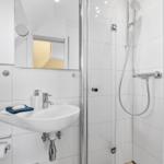 Bathroom with shower, sink, and mirror