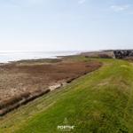 Green slope with view of coastal landscape and houses