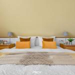 Bedroom with double bed, two nightstands, and decorative pillows.