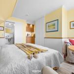 Bedroom with bed, sofa, and view into bathroom and kitchen.