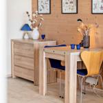 Holztisch mit zwei Stühlen, Schrank und Wanddekoration in einem Raum mit Holzwand.