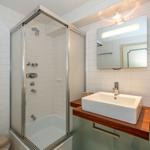 Badezimmer mit Dusche, Waschbecken und Toilette.
