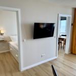 Wohnung mit Schlafzimmer, TV und Blick aufs Meer.
