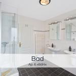 Badezimmer mit Dusche, zwei Waschbecken und Spiegeln.
