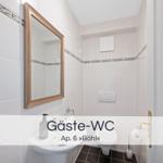 Gäste-WC mit Spiegel, Waschbecken und Toilette. Fliesen an den Wänden.