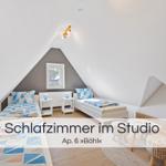 Zwei Betten im Dachgeschosszimmer mit Fenster und Nachttischen.