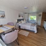 Schlafzimmer mit Bett, Esstisch, Küchenzeile und Fenster.