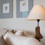 Sofa mit Kissen und Stehlampe mit Holzsockel