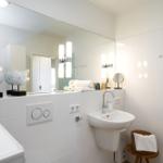 Badezimmer mit Spiegel, Waschbecken und Handtuchständer