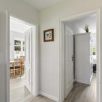 Hausflur mit Türen zu Esszimmer und Schlafzimmer, Wanddekoration und Holzboden.