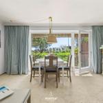 Esszimmer mit Tisch, Stühlen und Blick auf Garten. Vorhang und Schrank sind sichtbar.