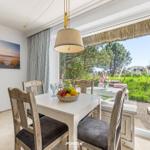 Esszimmer mit Tisch, Stühlen und Blick auf Garten.