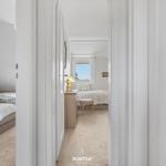 Zwei Schlafzimmer mit Blick auf den Himmel und Fenster. Beide Räume sind mit Bett und Möbeln eingerichtet.