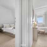 Zwei Schlafzimmer mit Betten, Schränken und Fenstern mit Blick.
