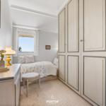 Schlafzimmer mit Bett, Schrank und Fenster mit Blick.