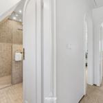 Dusche mit Mosaikfliesen, Schlafzimmer mit Fenster und Nachttisch.