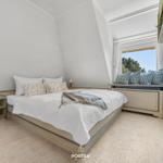 Schlafzimmer mit Bett, Fensterbank und Nachttischen