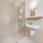 Bad mit Dusche, Waschbecken und Spiegel