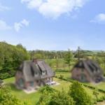 Haus mit Dach und Terrasse im grünen Umfeld