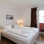 Schlafzimmer mit Doppelbett, Nachttisch und Stuhl vor Fenster mit Blick.