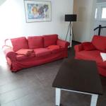 Zwei rote Sofas, ein Tisch und eine Wanddekoration im Wohnbereich.