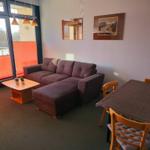 Heller Wohnbereich mit gemütlicher Sofaecke in strandnaher Ferienwohnung am Südstrand Fehmarn.