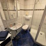 Helles Badezimmer mit Dusche und funktionaler Ausstattung für angenehmen Komfort im Ostseeurlaub.