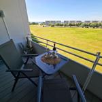 Gemütlicher Balkon mit Blick ins Grüne und Ostseeblick in der Ferne – ideal für entspannte Urlaubsmomente auf Fehmarn.