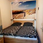 Gemütliches sep. Schlafzimmer mit Doppelbett und maritimem Wandmotiv für erholsame Nächte.