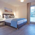Schlafzimmer mit Doppelbett, Balkon und Wandbild.