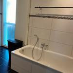 Badezimmer mit Dusche, Badewanne, Waschmaschine und Trockner und Zugang zum Balkon