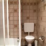 Bad mit Dusche, Toilette und Fliesenwand