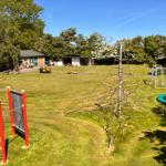 Großer Garten mit Klettergerüst, Trampolin und Fußballtor.