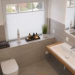 Badezimmer mit Fenster, Waschbecken und Toilette. Auf dem Fensterbrett stehen Dekorationsgegenstände.