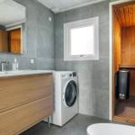 Bathroom with washing machine and sauna