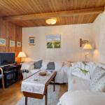 Living room with sofa, table, TV, and wooden ceiling.