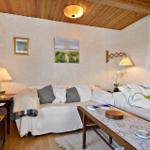 Living room with sofa, coffee table, and TV under wooden ceiling.