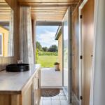 Bathroom with wooden walls, sink, and view onto the terrace.