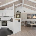 Kitchen with white built-in cabinetry and living area with sofa and table
