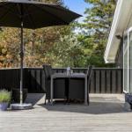 Deck with table, chairs, and umbrella beside house