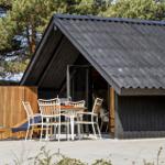 Black wooden house with terrace, table and chairs under a roof