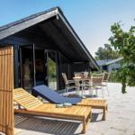 Terrace with lounge chairs, table and chairs in front of a modern house.