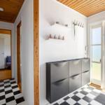 Entryway with black-and-white floor and shoe cabinet. Corridor to bedroom. Terrace with garden view.