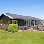Modern villa with terrace and garden. Grill, seating area, and flower bed.