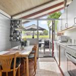 Kitchen with dining table, view to terrace with umbrella.