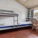 Room with bunk bed, wooden ceiling, and view of outdoor area.